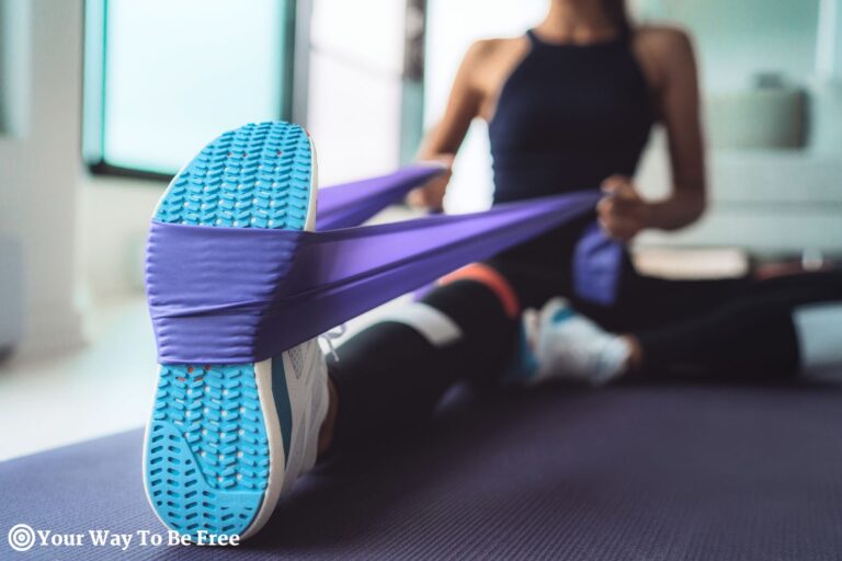 Resistance Band Exercise at Home. Woman Doing Pilates Workout Using Elastic Strap Pulling with Arms for Shoulder Training on Yoga Mat Indoors. home gym on a budget